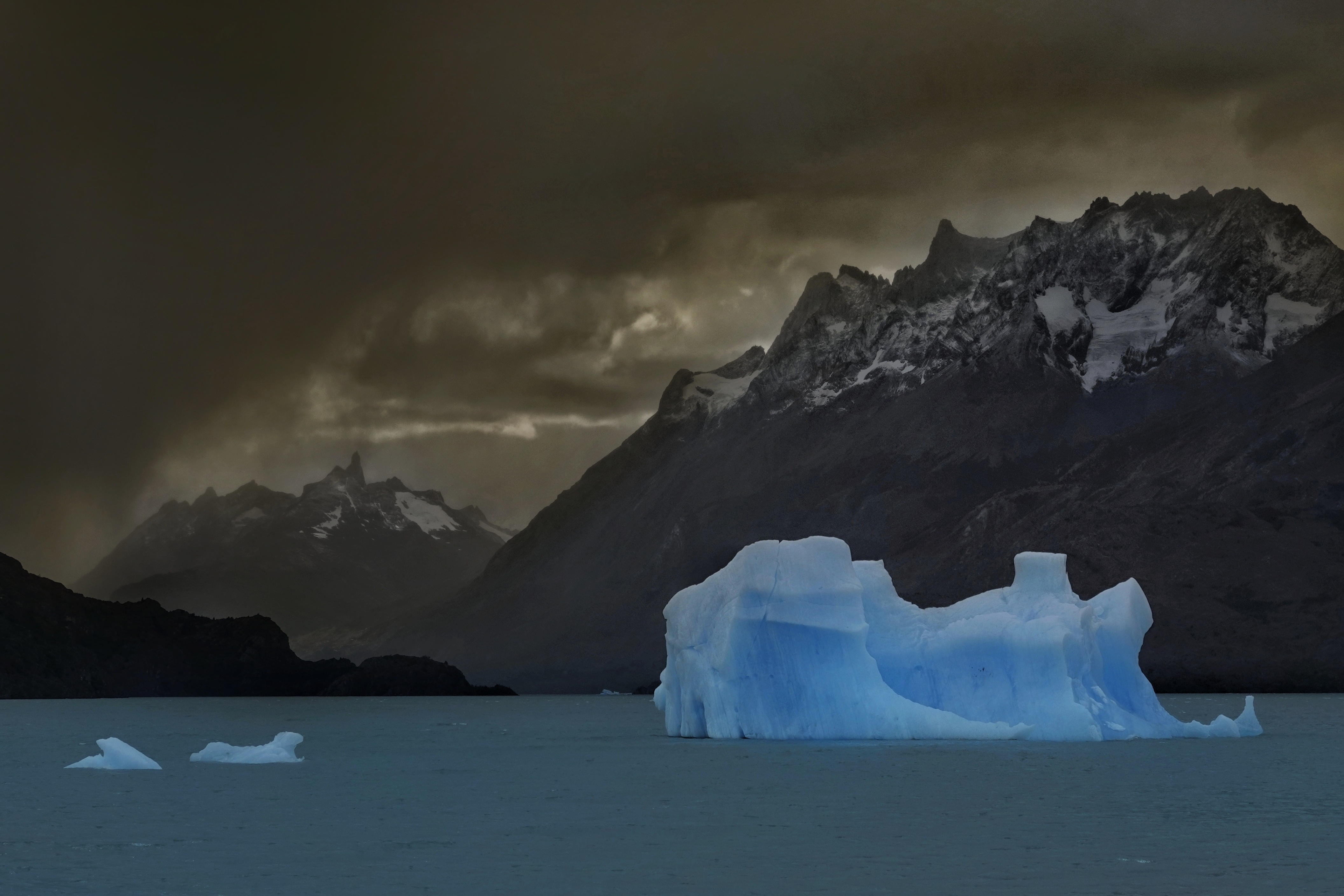 Iceberg bleu sur un lac sombre